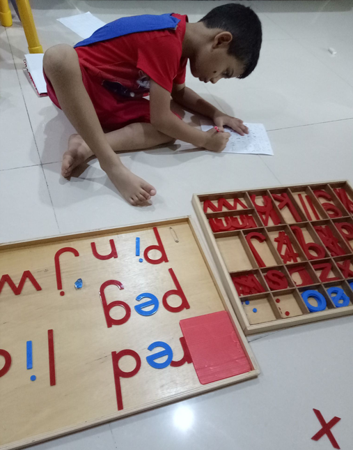 Lishaan working with Montessori grammar material